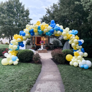 Blue and yellow balloon arch standing outside. 