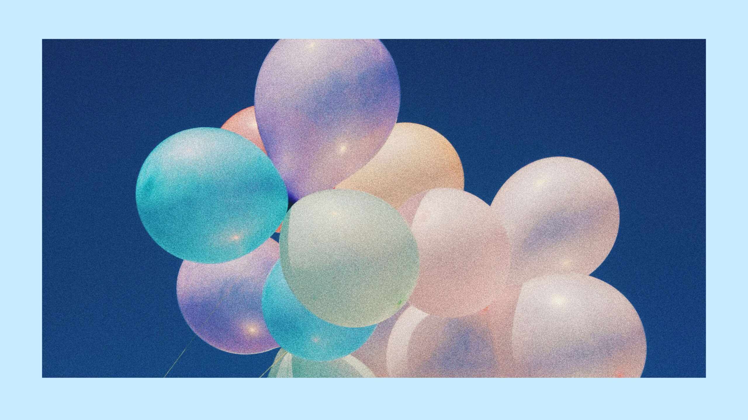 Colorful pastel helium balloons floating in the sky.